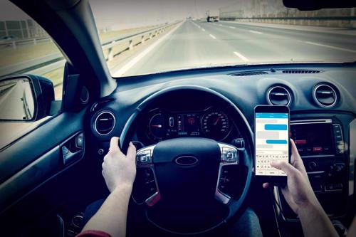 A motorist texting on their phone while driving.